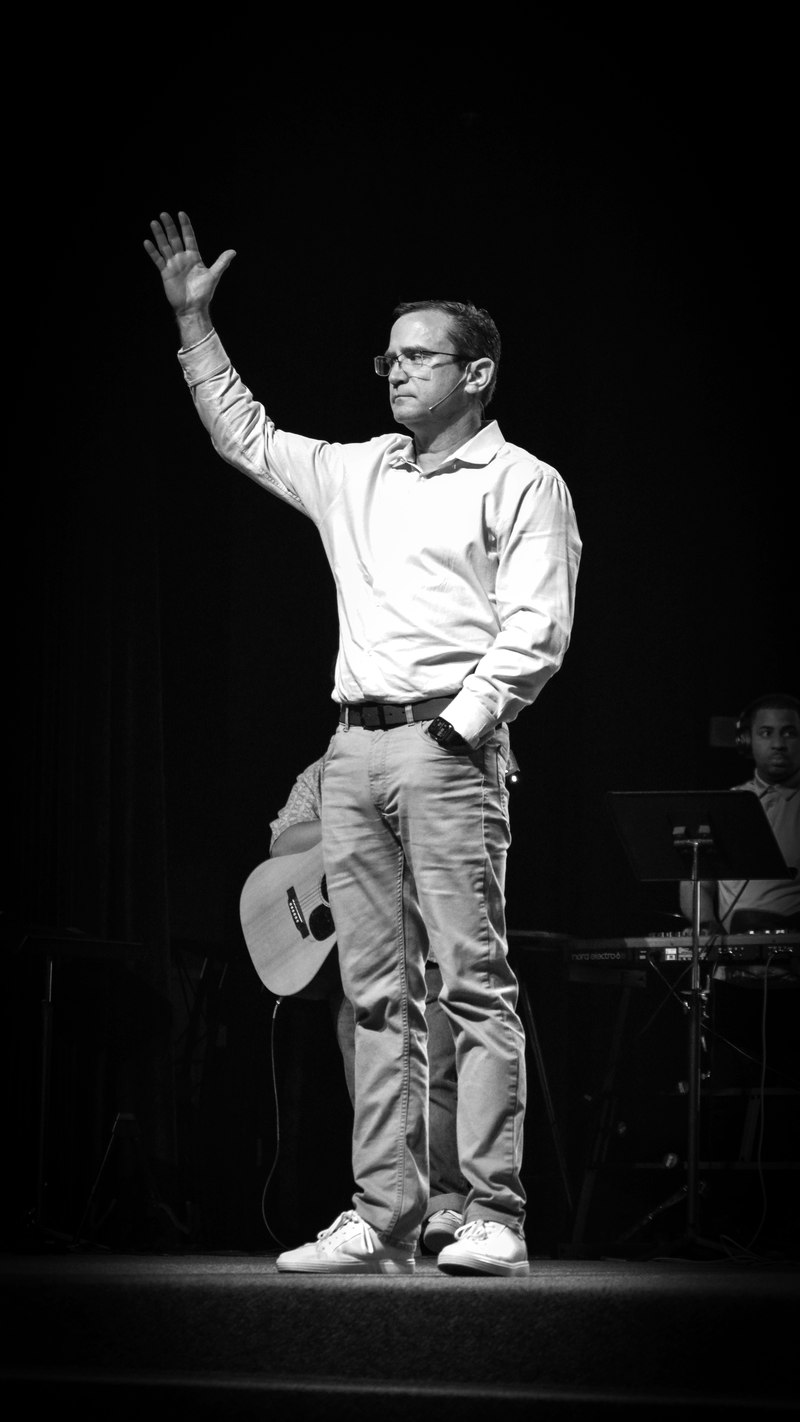 Mike Holt on stage with raised hand