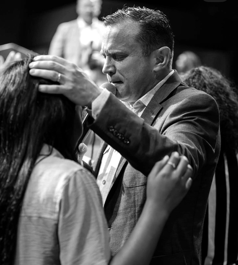 Mike Holt praying with someone