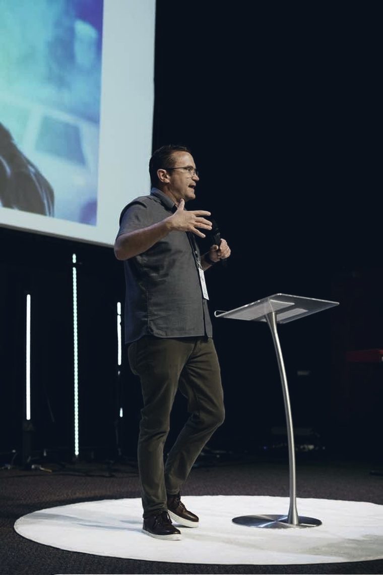 Mike Holt preaching from the stage